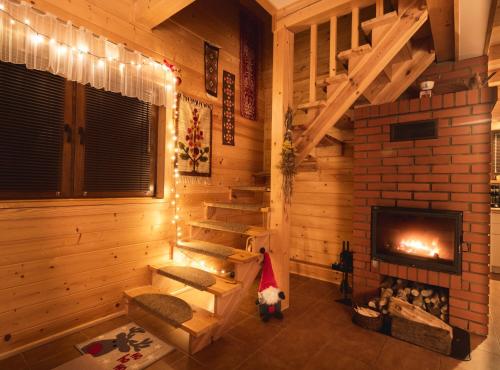 a room with a fireplace in a log cabin at Leśna 21 Dom Południe przy PUSZCZA BIAŁOWIESKA in Łuka
