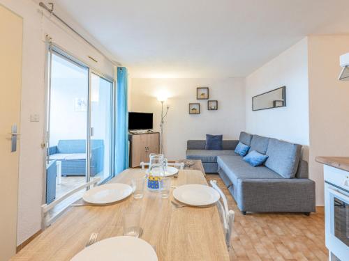 uma sala de estar com uma mesa e um sofá em Apartment Les terrasses de la Plage-4 by Interhome em Cap d'Agde