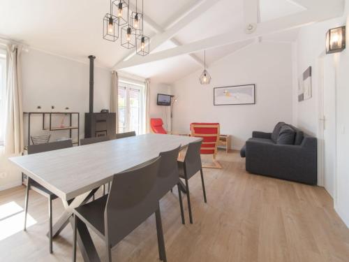 a dining room and living room with a table and chairs at Holiday Home Duinenhuisje 25 parking and shared pool by Interhome in De Haan