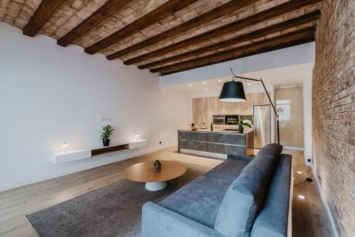 Petit Luxe St. Pere في تيراسا: غرفة معيشة مع أريكة زرقاء وطاولة