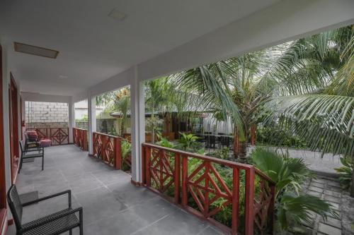 a balcony with chairs and palm trees at Aqua Blu Thoddoo in Thoddoo