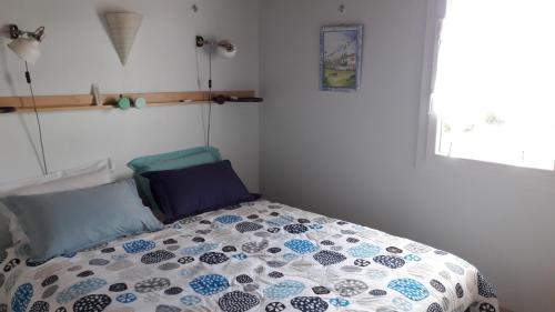 une chambre avec un lit avec une couette dessus dans l'établissement LA PIGOUILLE - Proche mer, à Bretignolles-sur-Mer