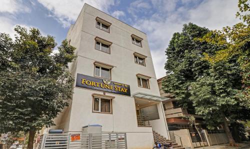 un edificio blanco alto con un letrero. en Treebo Trend Fortune Stay en Bangalore