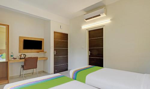 a bedroom with a bed and a desk with a computer at Treebo Fortune Stay in Bengaluru