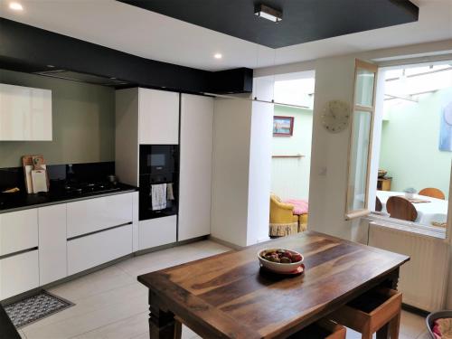- une cuisine avec une table en bois dans une chambre dans l'établissement Kermit - Maison proche plages, à Les Sables-dʼOlonne