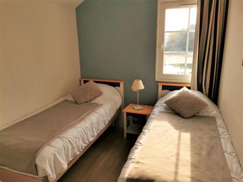 une petite chambre avec deux lits et une fenêtre dans l'établissement LE BOCAGE 38 - Bourgenay - Piscine chauffee, à Saint-Hilaire-de-Talmont