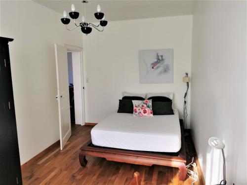 une chambre avec un lit et un lustre dans l'établissement Kermit - Maison proche plages, à Les Sables-dʼOlonne