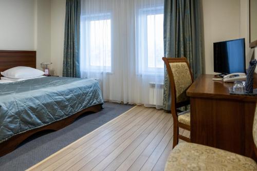 Habitación de hotel con cama y escritorio con ordenador en 40th Meridian Arbat Hotel, en Kolomna