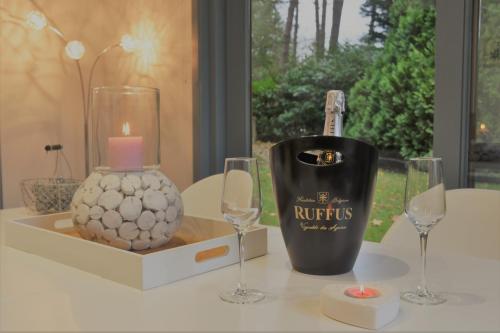 a table with wine glasses and a candle and a vase at La Maison de Lise in Ville-Pommeroeul