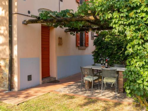 Peccioli的住宿－Apartment Cilamino by Interhome，一个带桌子和椅子的院子,有一座建筑