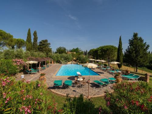 una gran piscina con mesas y sillas verdes en Apartment Melograno by Interhome, en Peccioli