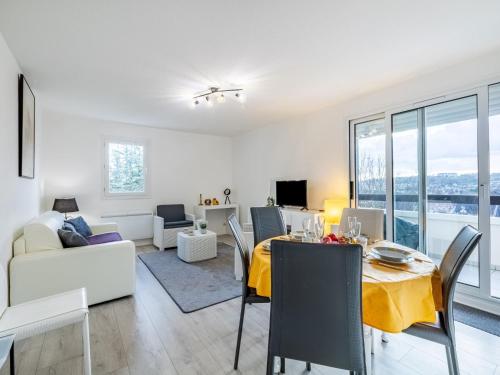 ein Wohnzimmer mit einem Esstisch und einem gelben Tischtuch in der Unterkunft Apartment Le Vert Coteau-3 by Interhome in Touques