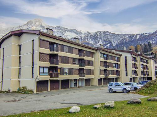 a large building with cars parked in a parking lot at Apartment Le Prarion by Interhome in Les Houches
