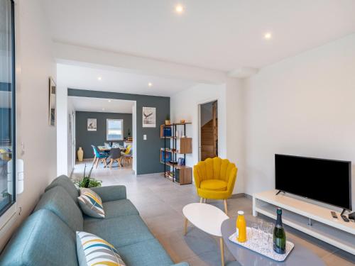 a living room with a blue couch and a tv at Holiday Home Villa Lanka by Interhome in Arzon