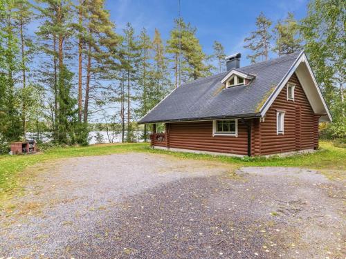 una cabaña en el bosque con una gran entrada de grava en Holiday Home Vihreä mökki by Interhome, en Kesälahti