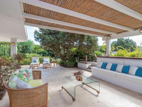 a patio with a couch and chairs and a table at Holiday Home Capichera by Interhome in Aglientu
