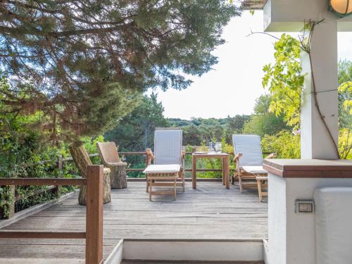 a deck with chairs and a table on a house at Holiday Home Capichera by Interhome in Aglientu