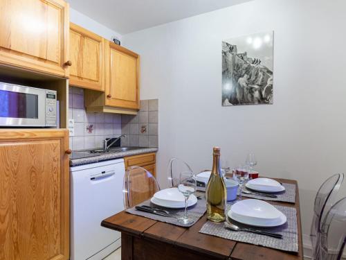 - une cuisine avec une table et une bouteille de vin dans l'établissement Apartment L'Espace Montagne-17 by Interhome, à Chamonix-Mont-Blanc