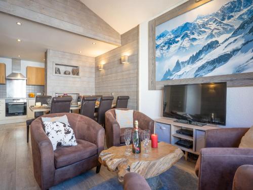 a living room with a tv and a table and chairs at Apartment Rond Point des Pistes - Val Claret-17 by Interhome in Tignes