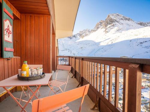 a balcony with a table and chairs and a snow covered mountain at Apartment Rond Point des Pistes - Val Claret-17 by Interhome in Tignes