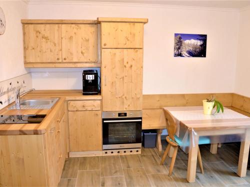 a small kitchen with wooden cabinets and a table at Apartment Ferienwohnung Wiesenhof by Interhome in Reith bei Seefeld