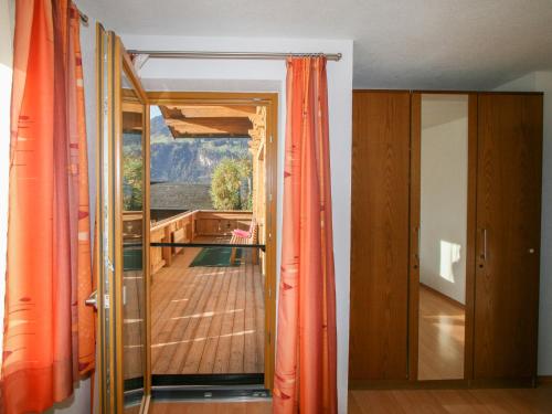 a room with orange curtains and a view of a balcony at Apartment Haus Wurm by Interhome in Bruck am Ziller