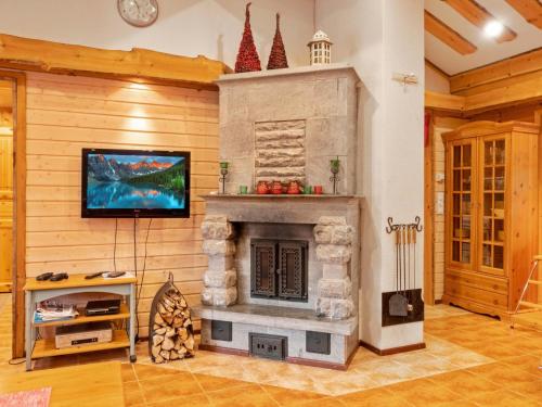 salon z kamiennym kominkiem i telewizorem z płaskim ekranem w obiekcie Holiday Home Lauri 5 by Interhome w mieście Sirkka