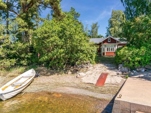 a boat sitting on the sand in front of a house at Holiday Home Elfvik by Interhome in Porvoo