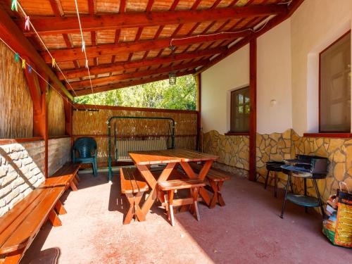 a patio with a wooden table and benches at Holiday Home Tamas by Interhome in Balatonőszöd