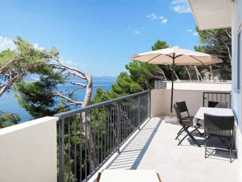 a balcony with a table and an umbrella at Holiday Home Lada - OMI205 by Interhome in Marusici 