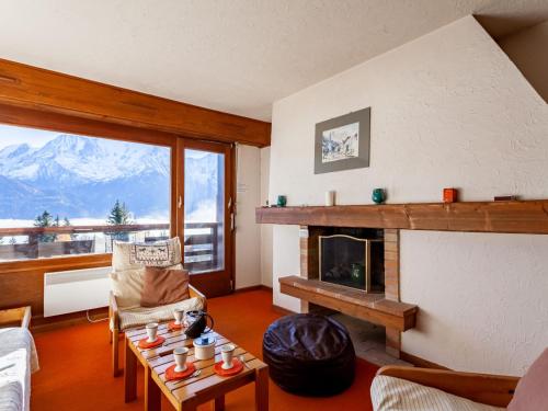 a living room with a fireplace and a table at Apartment La Christaz-6 by Interhome in Saint-Gervais-les-Bains