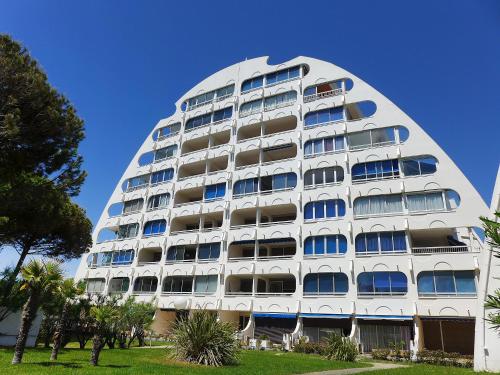 - un grand bâtiment blanc avec des fenêtres bleues dans l'établissement Apartment Les Marines de Haute-Plage-5 by Interhome, à La Grande Motte