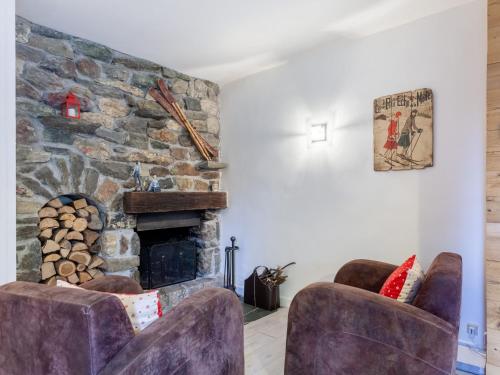 a living room with two chairs and a stone fireplace at Apartment Le Diorama by Interhome in Saint-Gervais-les-Bains