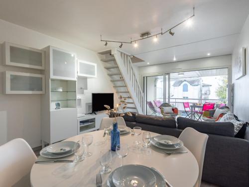 a dining room and living room with a table and chairs at Apartment Ker Eol by Interhome in Carnac