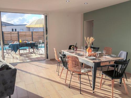 a dining room with a table and chairs and a patio at Holiday Home Les Lagons du Lividic by Interhome in Plounéour-Trez