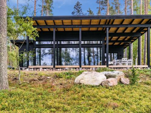 a house in the woods with a wooden roof at Holiday Home Villa saimaan joutsenlahti by Interhome in Äitsaari