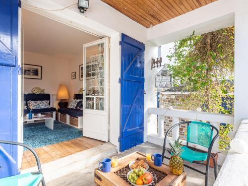 Cette chambre est dotée d'une porte bleue et d'une table avec des fruits. dans l'établissement Holiday Home Villa Kermario by Interhome, à Carnac