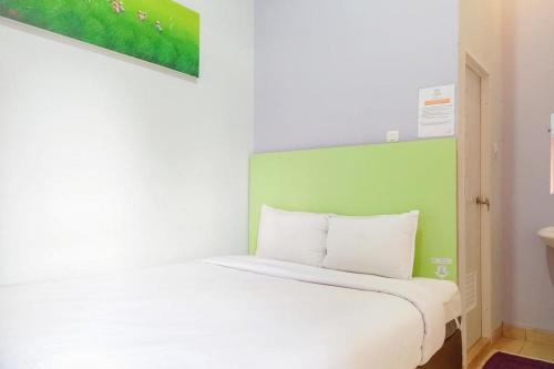 a white bed with a green headboard in a room at Paris Syariah Residence at Jalan Parangtritis Yogyakarta in Timuran