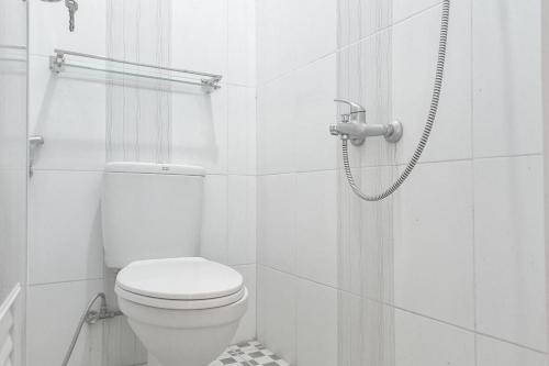 a white bathroom with a toilet and a shower at Paris Syariah Residence at Jalan Parangtritis Yogyakarta in Timuran