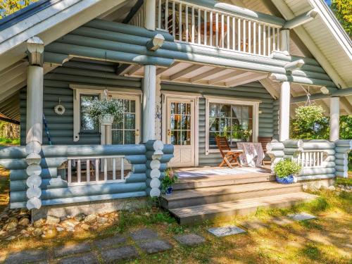 a house with a wooden porch with a deck at Holiday Home Honkaniemi by Interhome in Hiukkajoki