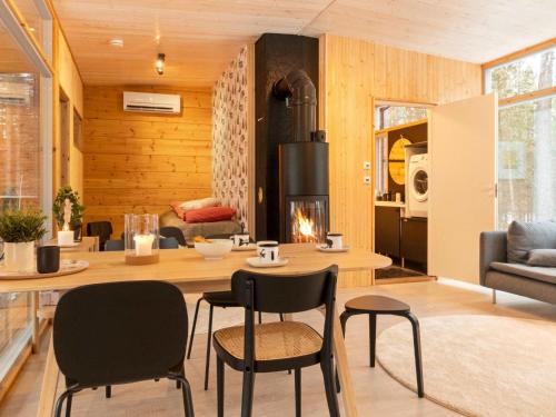 a living room with a table and chairs and a fireplace at Holiday Home Solokoto by Interhome in Inari