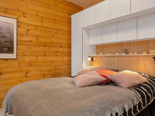 a bedroom with a bed with a wooden wall at Holiday Home Solokoto by Interhome in Inari