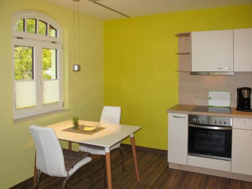 a kitchen with green walls and a table and chairs at Apartment Altherscher Hof-2 by Interhome in Zarrentin