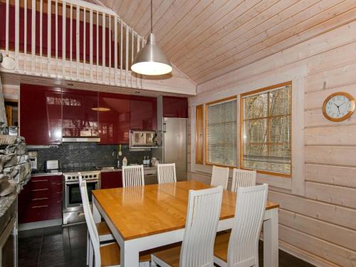 cocina con mesa de madera y sillas blancas en Holiday Home Anttoora 2 by Interhome, en Pori