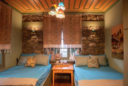 two beds in a room with a stone wall at Dandy Villas Metsovo-Metska-Down Town-Up to 7 in Metsovo