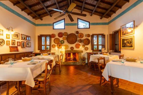 a dining room with tables and a fireplace at Agriturismo Canales in Dorgali