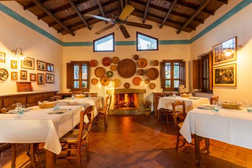 comedor con mesas y chimenea en Agriturismo Canales, en Dorgali