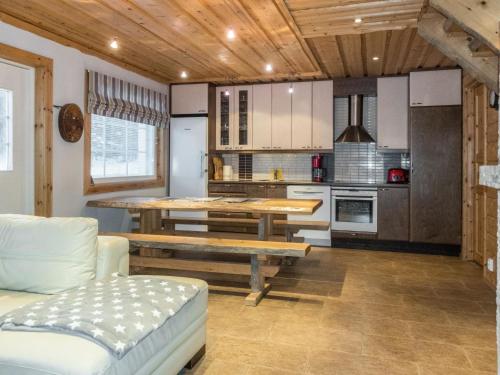 a living room with a table and a kitchen at Holiday Home Rapsakka a by Interhome in Levi