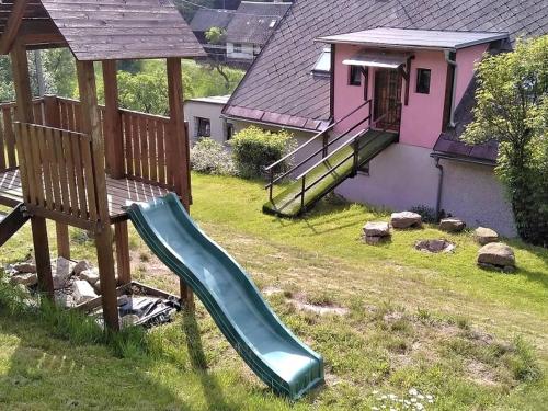 eine grüne Rutsche in einem Hof neben einem Haus in der Unterkunft Holiday Home Chlívce u Hronova-5 by Interhome in Chlívce
