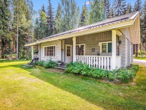 ein kleines weißes Haus mit einer Veranda im Gras in der Unterkunft Holiday Home Kiviniemi by Interhome in Hiukkajoki